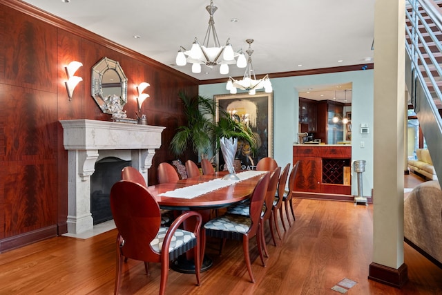 dining room featuring ornamental molding, hardwood / wood-style floors, and an inviting chandelier