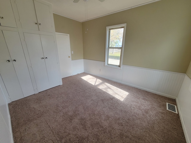 unfurnished bedroom featuring ceiling fan, a closet, and carpet floors