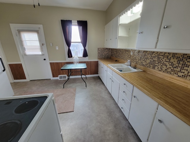 kitchen with white cabinets, a wealth of natural light, sink, and electric stove