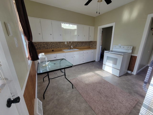 kitchen featuring white electric range oven, sink, backsplash, a wealth of natural light, and white cabinets