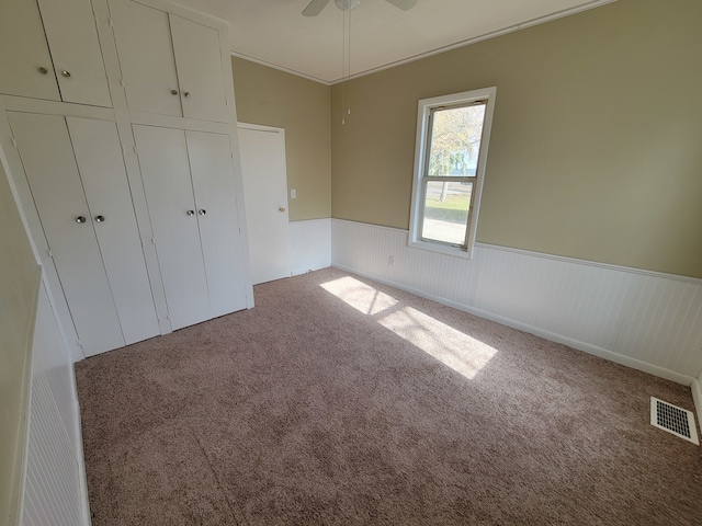 unfurnished bedroom with ceiling fan, a closet, and carpet floors