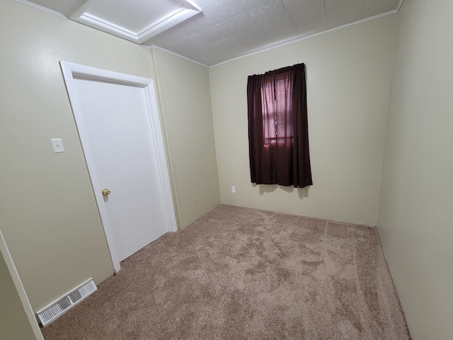 carpeted empty room featuring crown molding