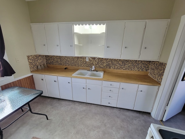 kitchen with white cabinetry, decorative backsplash, and sink