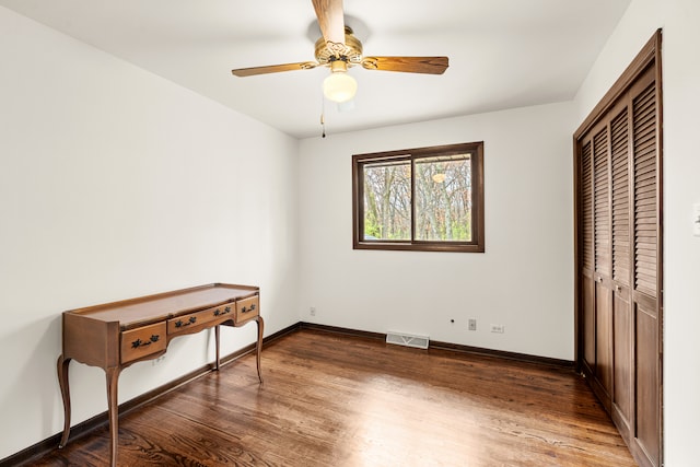 bedroom with ceiling fan, a closet, and dark wood-type flooring