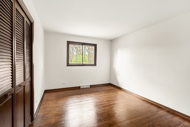 unfurnished bedroom featuring wood-type flooring and a closet