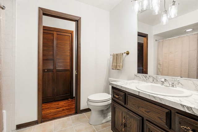 bathroom featuring toilet, vanity, tile patterned floors, and a notable chandelier