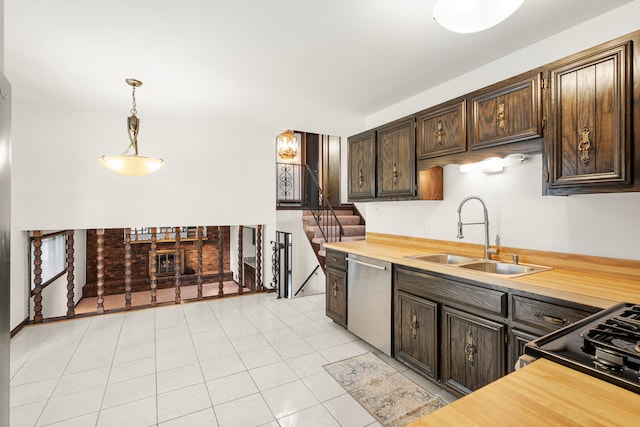 kitchen with dishwasher, sink, hanging light fixtures, dark brown cabinets, and light tile patterned flooring