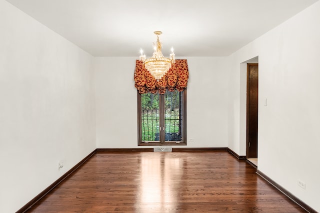 unfurnished room with a chandelier and dark hardwood / wood-style floors