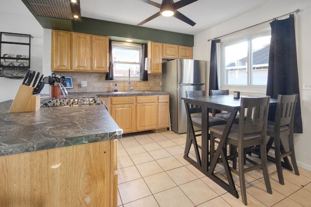 kitchen featuring stainless steel refrigerator, backsplash, sink, and light brown cabinets