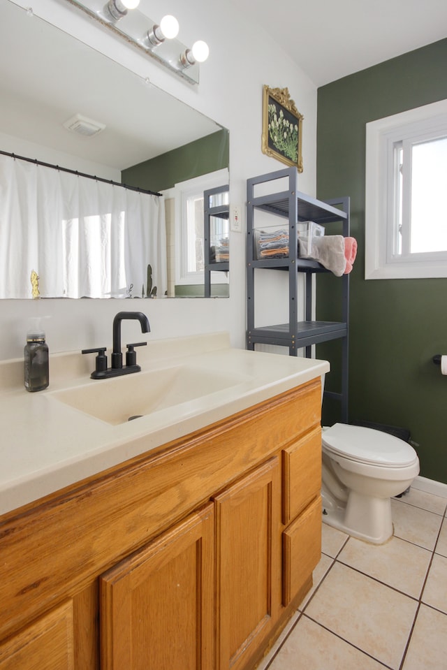 bathroom with tile patterned flooring, vanity, and toilet