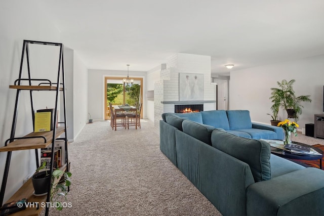 carpeted living room with a fireplace and a notable chandelier