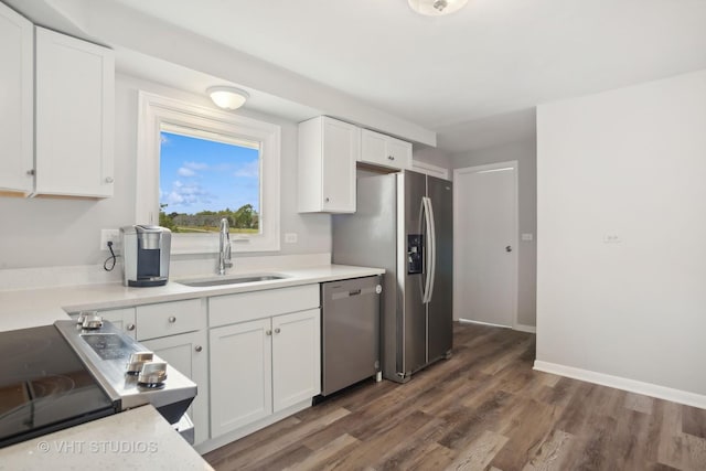 kitchen featuring appliances with stainless steel finishes, white cabinetry, dark wood-type flooring, and sink