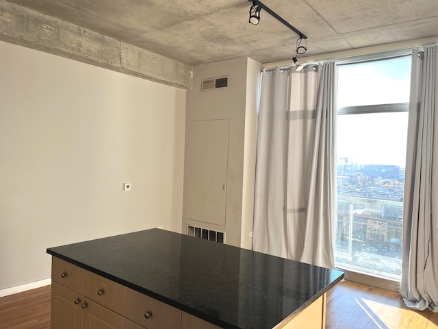 kitchen featuring dark hardwood / wood-style flooring, hanging light fixtures, and dark stone countertops