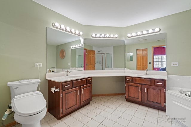 full bath with a shower stall, two vanities, and a sink