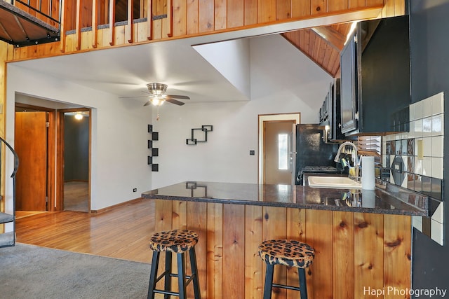 kitchen featuring sink, a kitchen bar, ceiling fan, and kitchen peninsula