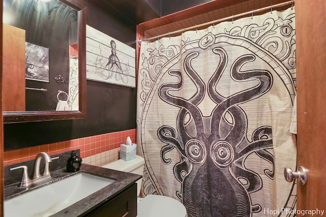 bathroom featuring backsplash, vanity, and toilet