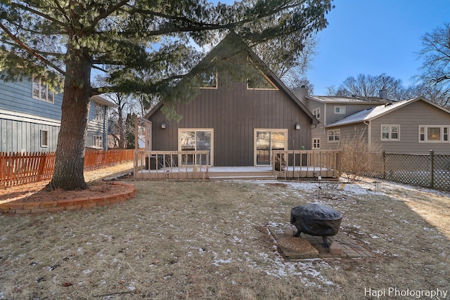 back of house with a fire pit and a wooden deck