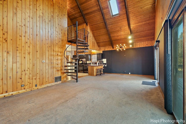 unfurnished living room featuring carpet flooring, wooden walls, beamed ceiling, high vaulted ceiling, and wood ceiling