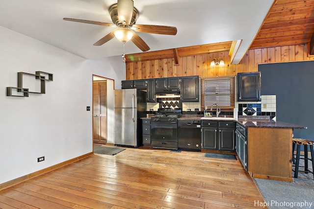 kitchen with black dishwasher, ceiling fan, stainless steel fridge, gas stove, and beam ceiling