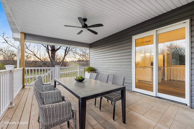 wooden terrace with outdoor dining area and a ceiling fan