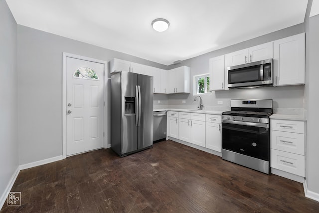 kitchen with dark wood-type flooring, white cabinetry, sink, and stainless steel appliances