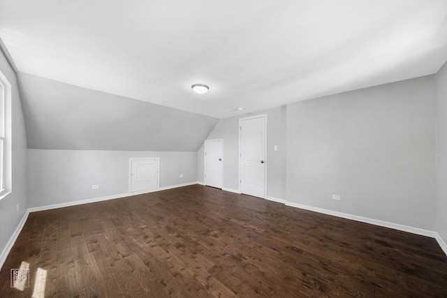 additional living space featuring dark hardwood / wood-style flooring and vaulted ceiling