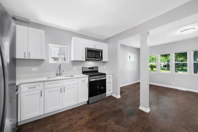 kitchen with white cabinetry, appliances with stainless steel finishes, dark wood-type flooring, and sink