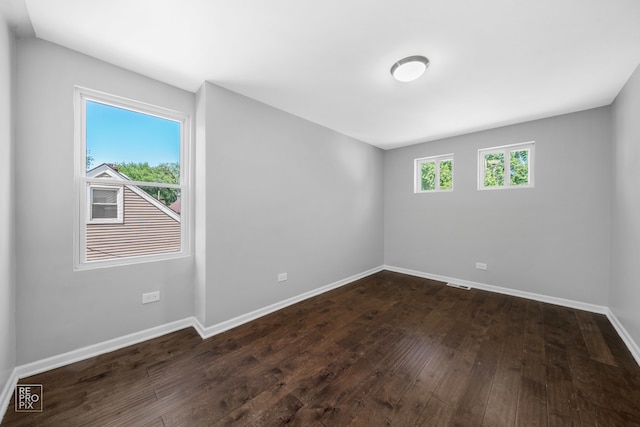 unfurnished room with dark wood-type flooring