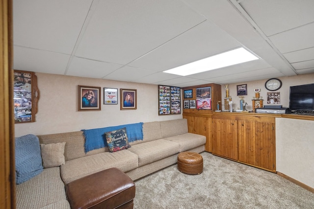 living room featuring a drop ceiling and light carpet