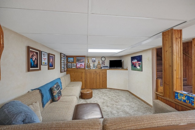 living room featuring a drop ceiling and carpet flooring