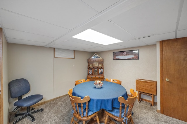 carpeted dining room with a paneled ceiling