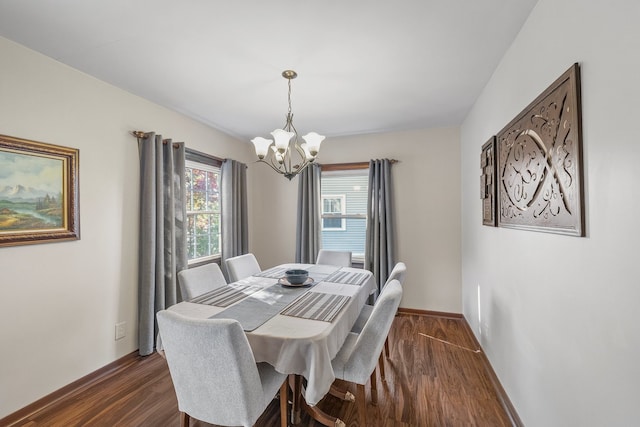 dining area with dark hardwood / wood-style floors and a chandelier