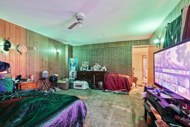 bedroom with ceiling fan and wood walls