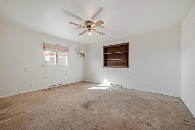 carpeted empty room featuring a baseboard heating unit, built in shelves, and ceiling fan