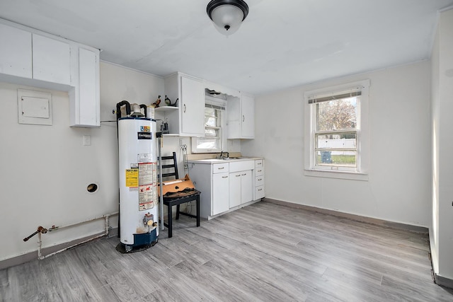 kitchen featuring white cabinets, gas water heater, a wealth of natural light, and light hardwood / wood-style flooring