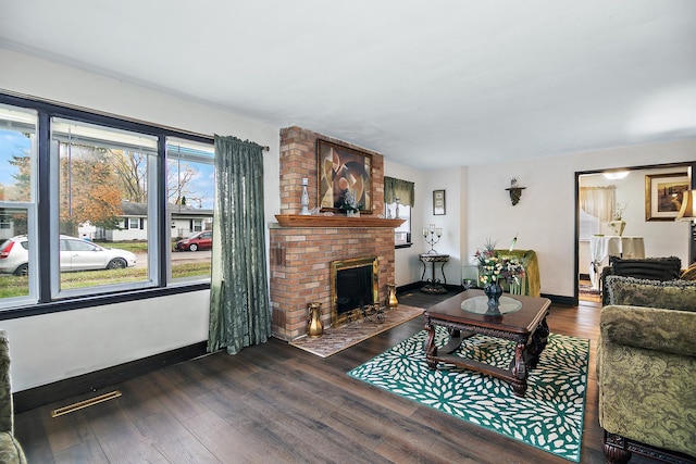 living room with dark hardwood / wood-style floors and a brick fireplace