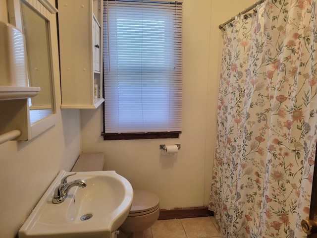 bathroom featuring tile patterned flooring, toilet, sink, and walk in shower