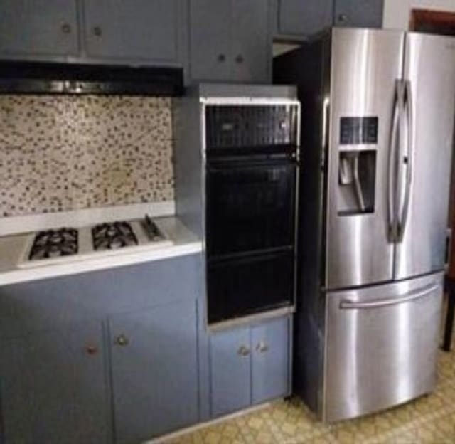 kitchen featuring gray cabinets, extractor fan, and stainless steel appliances