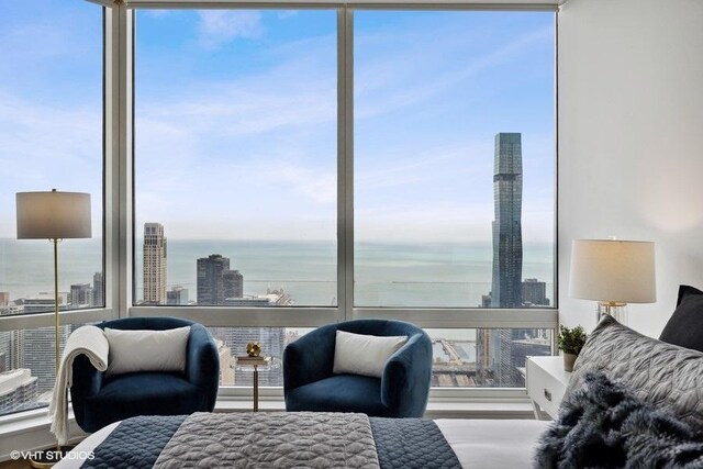 bedroom featuring a water view and floor to ceiling windows