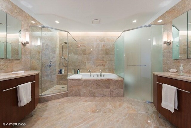 bathroom featuring plus walk in shower, vanity, and tile walls