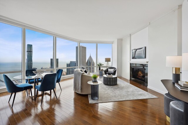 living room with dark hardwood / wood-style floors, a wall of windows, and a water view