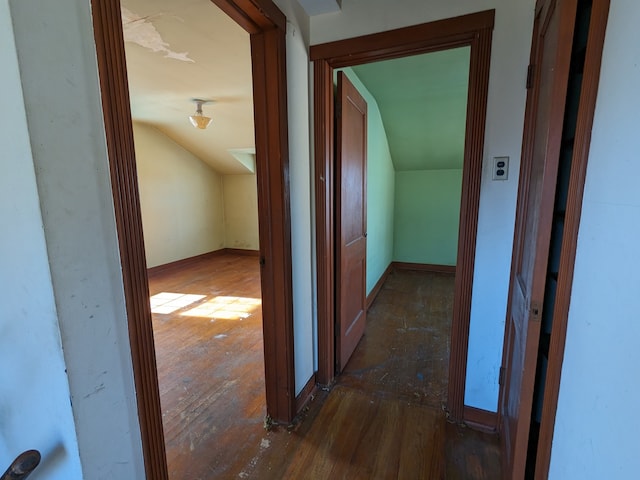 corridor featuring dark wood-type flooring and vaulted ceiling