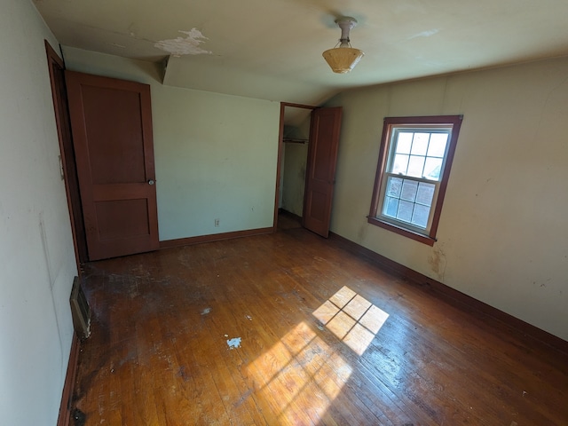 empty room with dark hardwood / wood-style flooring