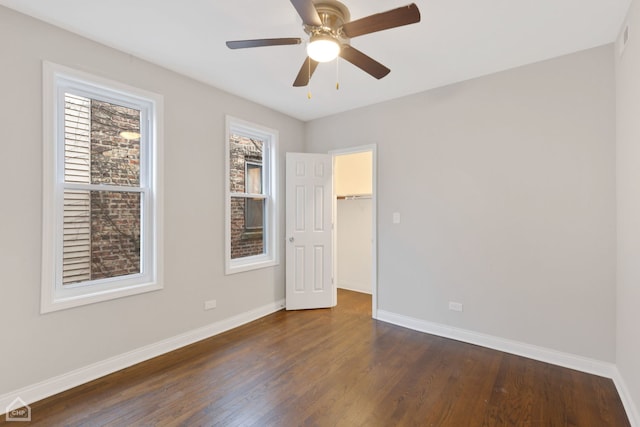 unfurnished room featuring dark hardwood / wood-style flooring, a wealth of natural light, and ceiling fan