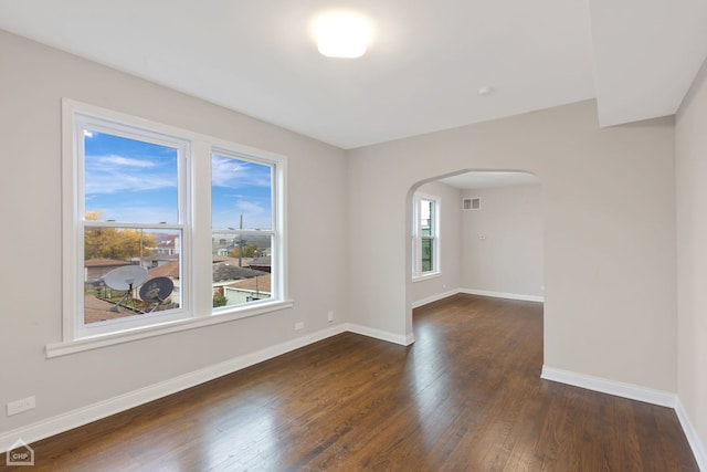 empty room featuring dark hardwood / wood-style flooring and a healthy amount of sunlight