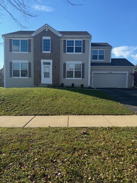 view of front of property featuring a front yard and a garage