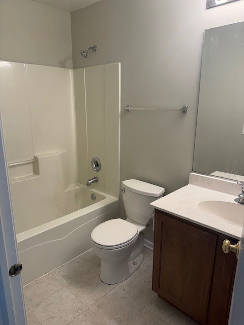 full bathroom featuring toilet, vanity, tile patterned flooring, and bathing tub / shower combination