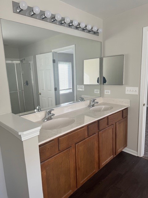 bathroom with walk in shower, wood-type flooring, and vanity