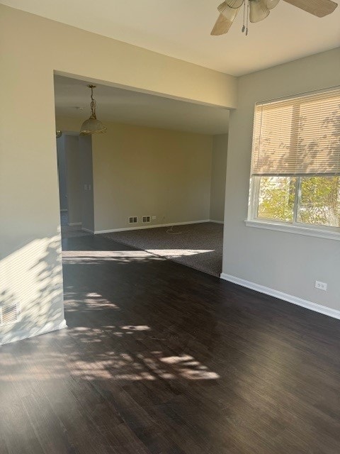 spare room with dark hardwood / wood-style flooring and ceiling fan