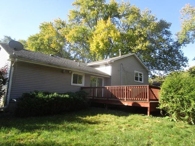 back of property featuring a yard and a wooden deck